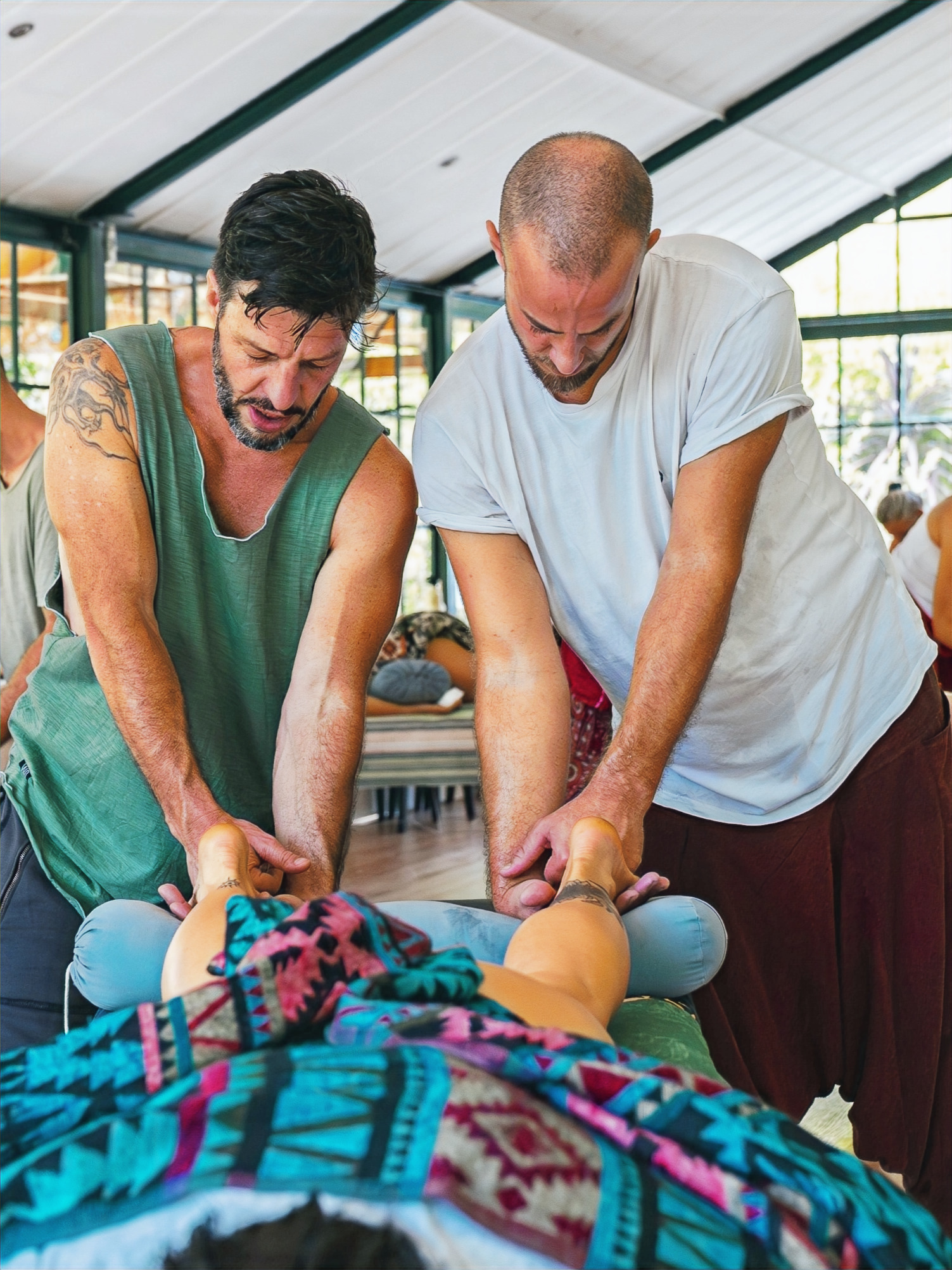 Practitioner exploring body regions during a bodywork training session